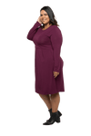 Curvy model facing the side wearing long sleeved, knee length burgundy dress. Featuring pockets, a rounded neckline, and pleated front. Robyn available in sizes 6-26