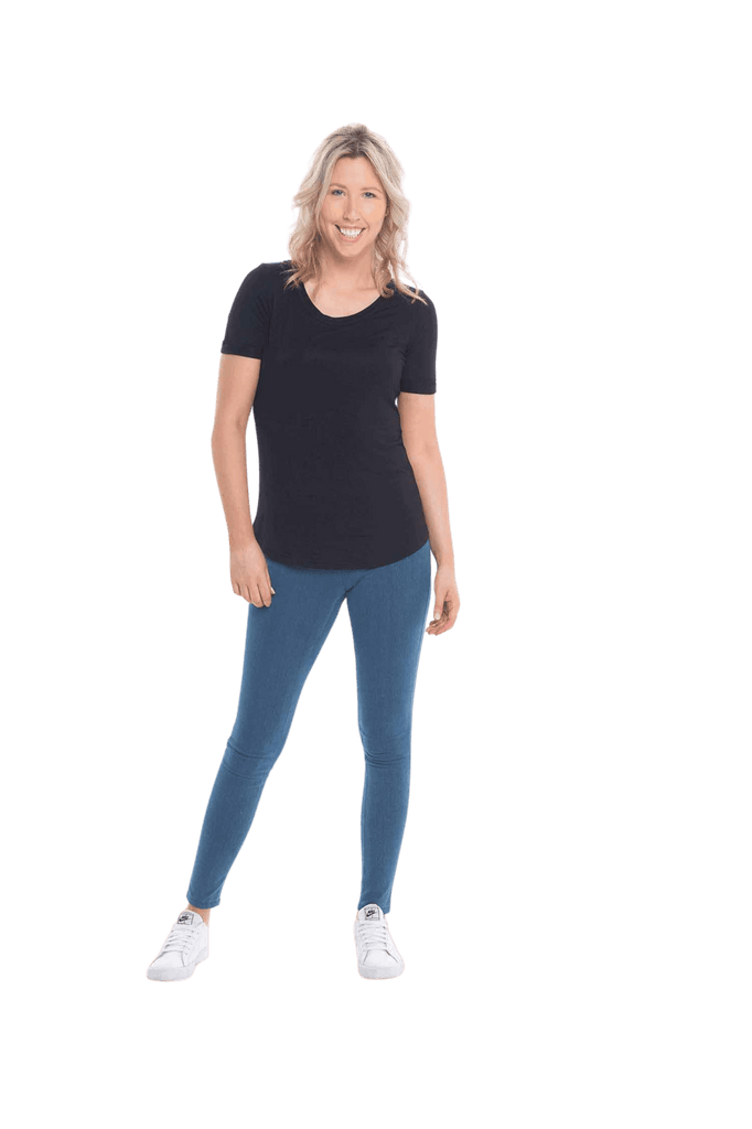 Petite model facing the camera wearing black short sleeved tee, featuring rounded neckline, and scooped hem. Stevie available in sizes 6-26