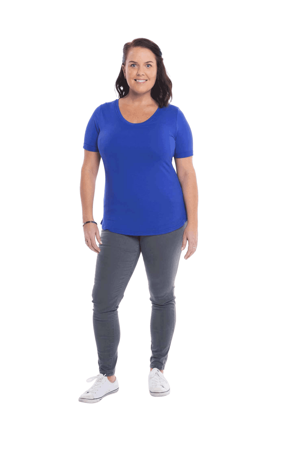 Petite model facing the camera wearing cobalt blue short sleeved tee, featuring rounded neckline, and scooped hem. Stevie available in sizes 6-18