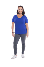 Petite model facing the camera wearing cobalt blue short sleeved tee, featuring rounded neckline, and scooped hem. Stevie available in sizes 6-18