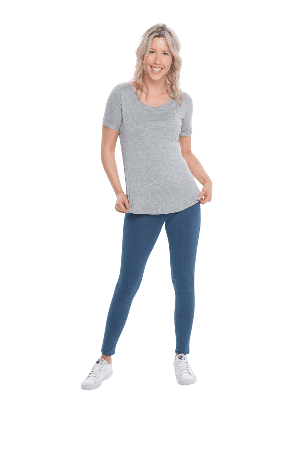 Petite model facing the camera wearing light grey short sleeved tee, featuring rounded neckline, and scooped hem. Stevie available in sizes 6-26