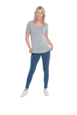 Petite model facing the camera wearing light grey short sleeved tee, featuring rounded neckline, and scooped hem. Stevie available in sizes 6-26