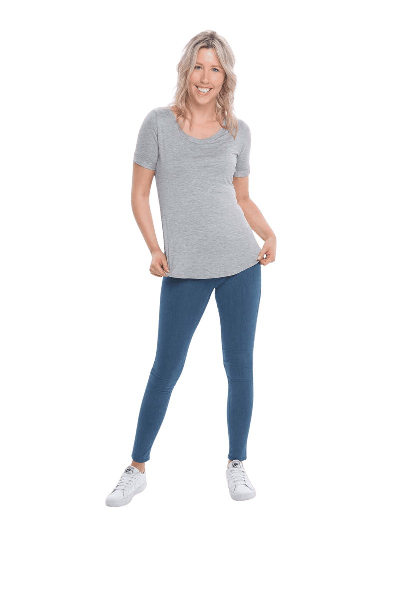 Petite model facing the camera wearing light grey short sleeved tee, featuring rounded neckline, and scooped hem. Stevie available in sizes 6-26