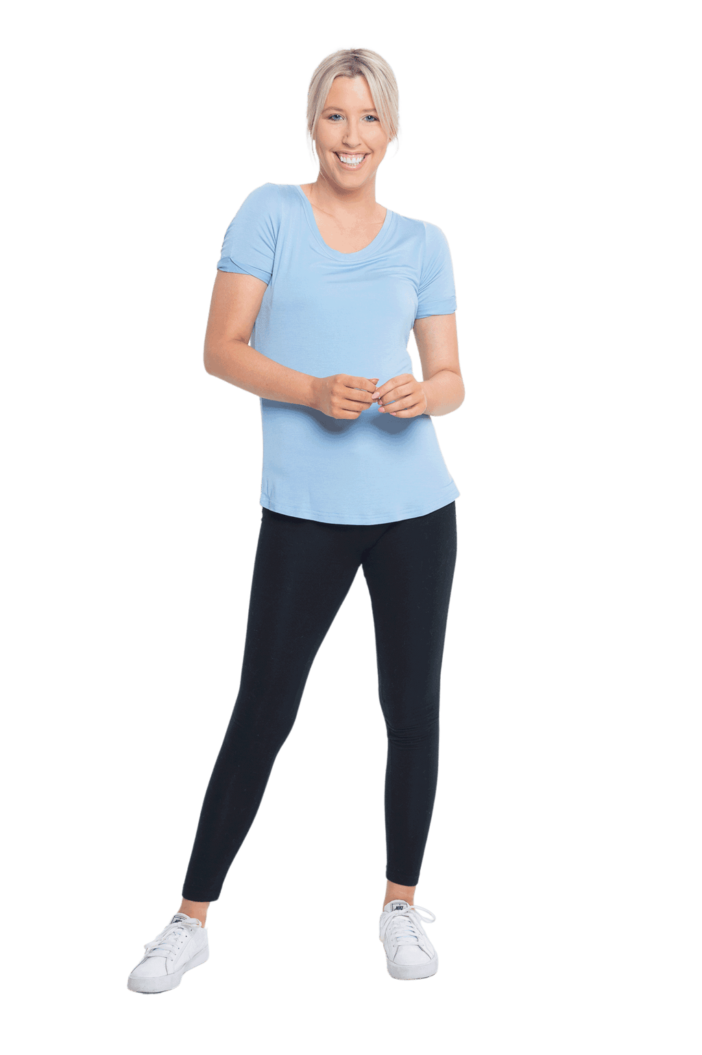 Petite model facing the camera wearing light blue short sleeved tee, featuring rounded neckline, and scooped hem. Stevie available in sizes 6-18