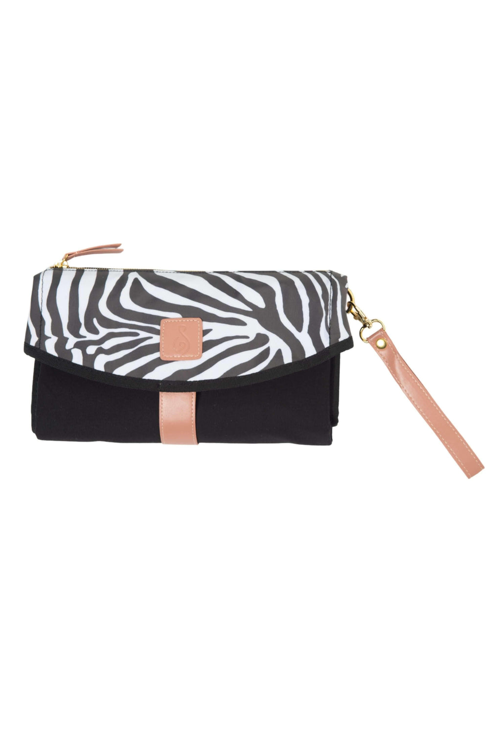 The All Rounder Change Mat shown laying folded up with sand coloured wrist strap. Black rectangular clutch with zebra print curved closing and sand coloured square badge, wrist strap and zip handle.
