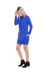 Petite model facing the side wearing cobalt blue long sleeved tunic as a dress with boots, featuring pockets and a faux hoodie collar in a comfy, relaxed fit. Tori available in sizes 6-18