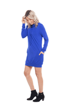 Petite model facing the side wearing cobalt blue long sleeved tunic as a dress with boots, featuring pockets and a faux hoodie collar in a comfy, relaxed fit. Tori available in sizes 6-18