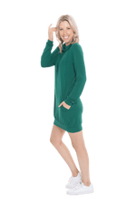 Petite model facing the side wearing bottle green long sleeved tunic as a dress with sneakers, featuring pockets and a faux hoodie collar in a comfy, relaxed fit. Tori available in sizes 6-26
