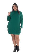 Curvy model facing the camera wearing bottle green long sleeved tunic as a dress with boots, featuring pockets and a faux hoodie collar in a comfy, relaxed fit. Tori available in sizes 6-26