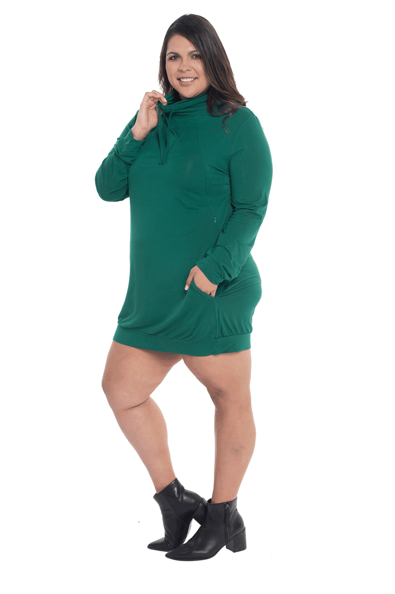 Curvy model facing the side wearing bottle green long sleeved tunic as a dress with boots, featuring pockets and a faux hoodie collar in a comfy, relaxed fit. Tori available in sizes 6-26