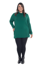 Curvy model facing the camera wearing bottle green long sleeved tunic as a top with black pants, featuring pockets and a faux hoodie collar in a comfy, relaxed fit. Tori available in sizes 6-26