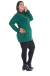 Curvy model facing the side wearing bottle green long sleeved tunic as a top with black pants, featuring pockets and a faux hoodie collar in a comfy, relaxed fit. Tori available in sizes 6-26