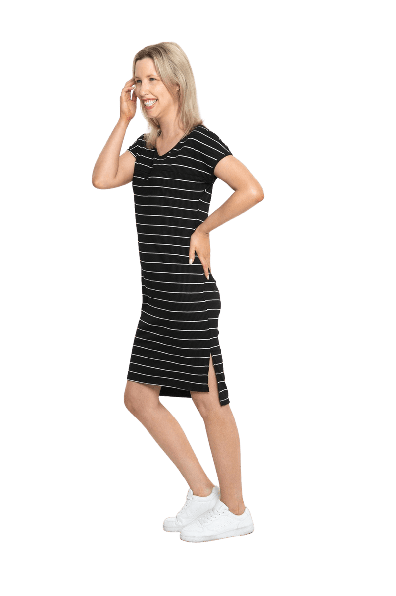 Petite model facing the side wearing black with white pin striped shift dress, featuring slight v neck and side splits. Zoe available in sizes 6-18