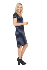 Petite model facing the side wearing navy with white pin striped shift dress, featuring slight v neck and side splits. Zoe available in sizes 6-18